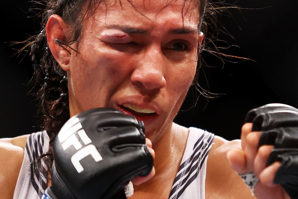 Taila Santos squints at Valentina Shevchenko during their title fight at UFC 275.