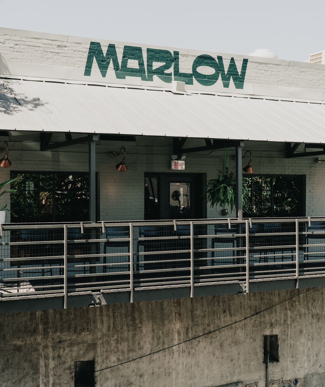 The outdoor space of a bar with the words MARLOW on the awning.