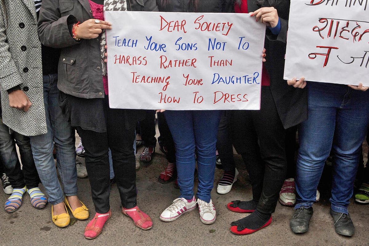 FILE - In this Wednesday, Jan. 2, 2013 file photo, Indian women carry signs as they march to mourn the death of a gang rape victim in New Delhi, India. For decades, women have had little choice but to walk away when groped in a crowded bus or train, or to