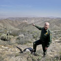 In this Monday, March 25, 2013 photo, Border Patrol agent Richard Gordon, a 23-year veteran of the agency, points to a route used by illegal immigrants that runs through rugged mountainous terrain in the Boulevard area east of San Diego, in Boulevard, Calif. For the past 16 years, Gordon has been one of the top "sign-cutters" or trackers in the Border Patrol. 