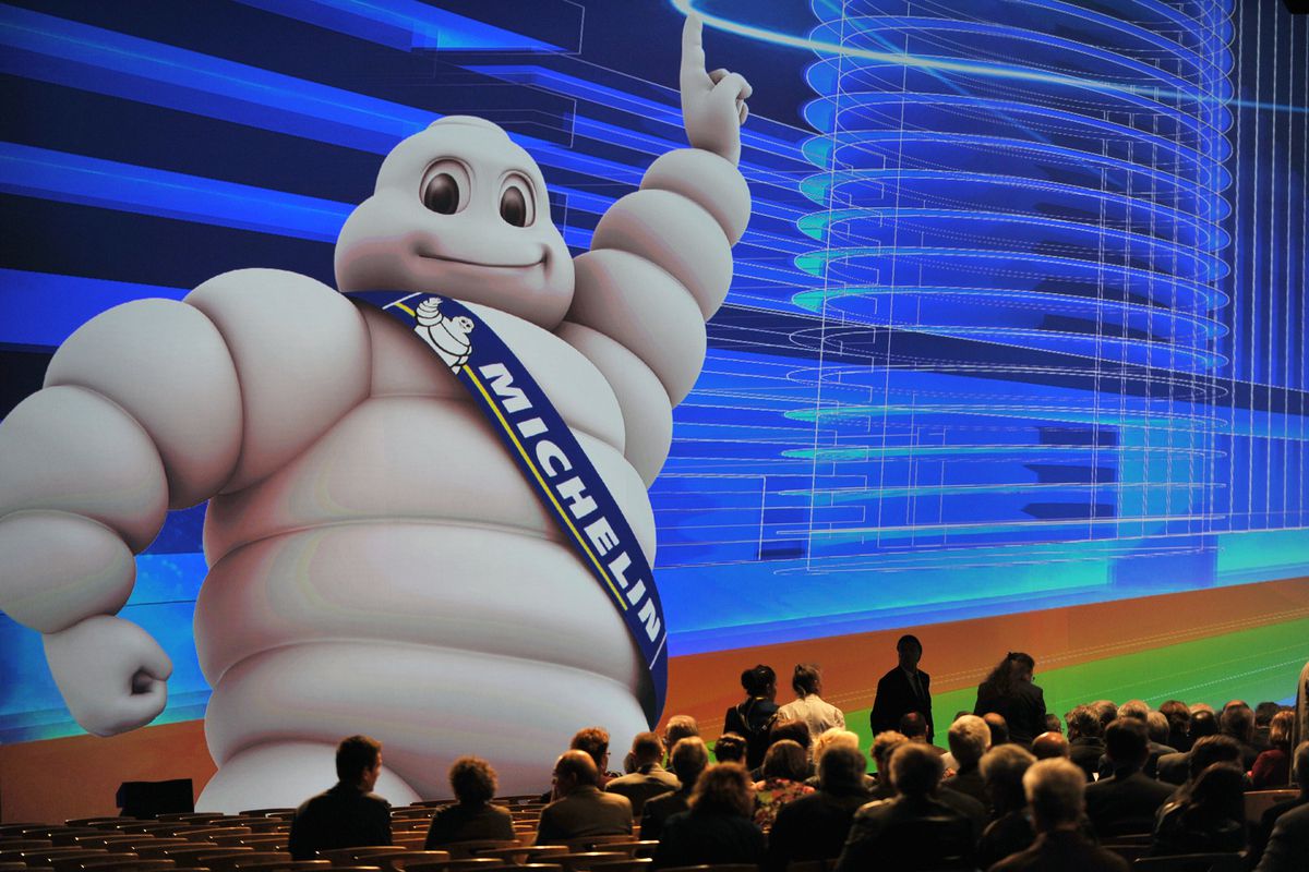 The Michelin star mascot Bibendum towers over an audience.