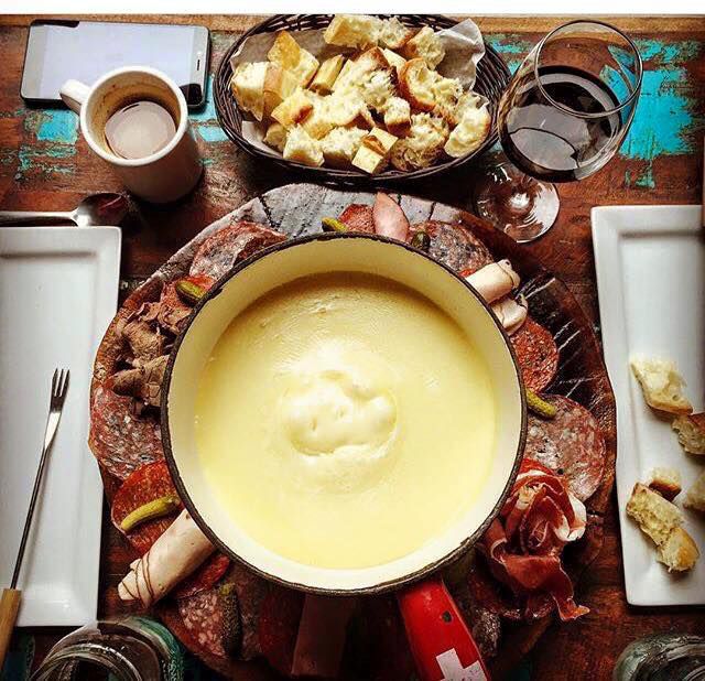 A fondue pot filled with cheese, pictured from above.