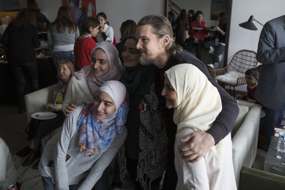 Syrian refugees gather around actor Ethan Hawke -- (clockwise) Maria of Damascus, Aya of Damascus, Betoul of Damascus and Iman of Idlib -- to pose for a picture during a traditional Syrian lunch to honor the refugees featured in the Sundance Film "This Is