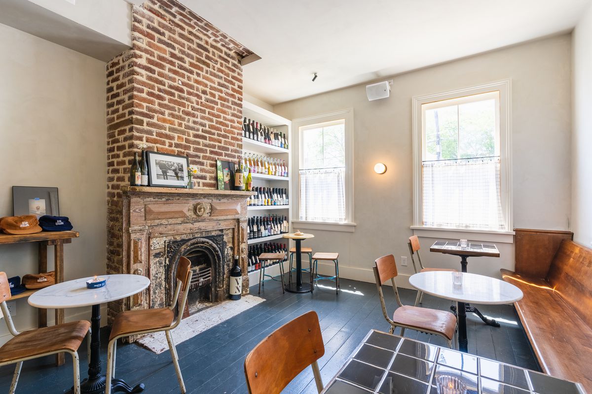 Brick fireplace surrounded by bistro tables.