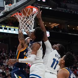 Utah Jazz guard Jordan Clarkson, left, dunks the ball past Minnesota Timberwolves defenders during an NBA game at Vivint Arena in Salt Lake City on Thursday, Dec. 23, 2021.