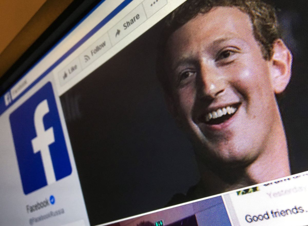 Facebook CEO Mark Zuckerberg on a computer screen with the Facebook logo.