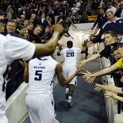 Utah State players are greeted by fans as they leave the court following NCAA basketball against UNLV in Logan Tuesday, Feb. 24, 2015.

