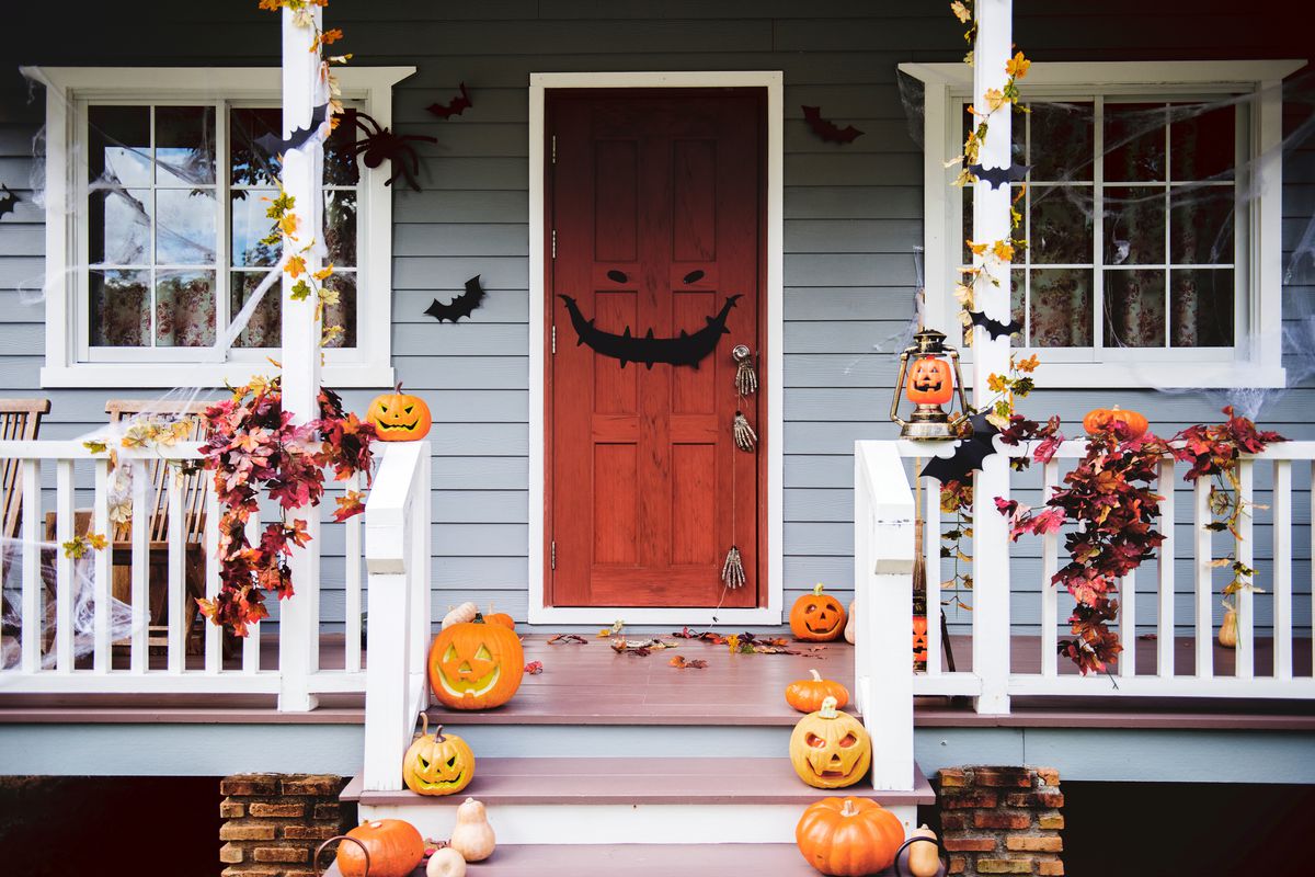 best spooky decor with jack-o-lanterns, fall leaves, and other Halloween decorations on front porch of a house
