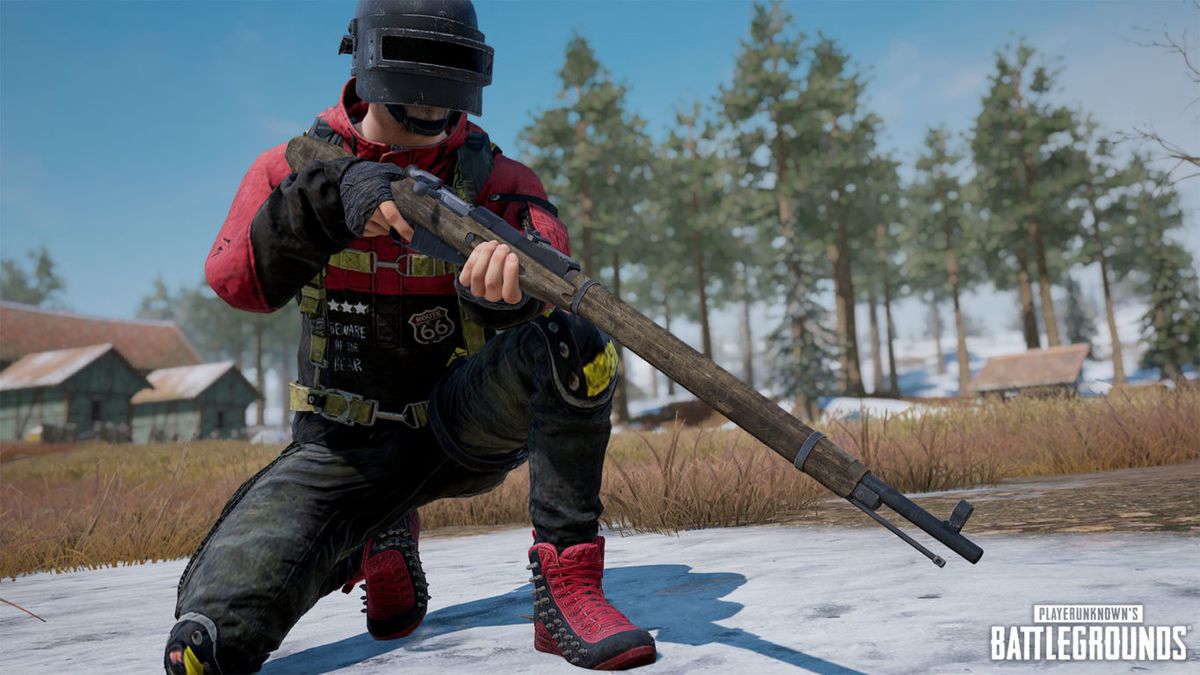 A player stands with a bolt-action rifle in a snowy field in PUBG