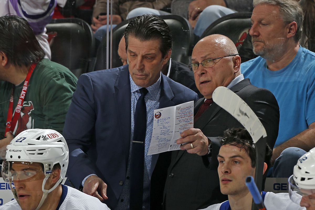 New York Islanders head coach Barry Trotz talks to associate coach Lane Lambert during the third period against the New Jersey Devils at the Prudential Center on April 3, 2022 in Newark, New Jersey. The Islanders defeated the Devils 4-3.
