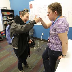 Hailey Witham fist-bumps Jessica Drake, a special education paraprofessional, at the American International School of Utah in Murray on Friday, May 3, 2019.