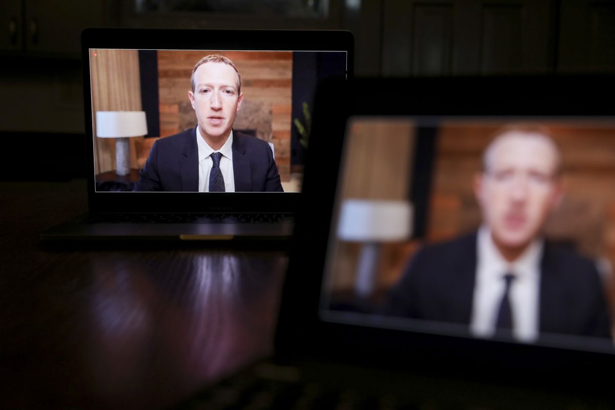 Facebook CEO Mark Zuckerberg on two laptop screens at a congressional hearing.