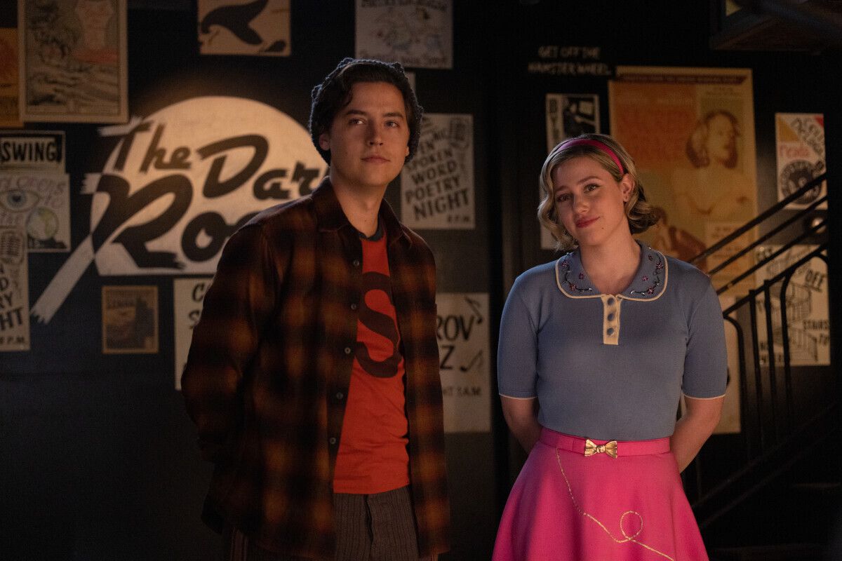 Jughead (Cole Sprouse) and Betty (Lili Reinhart) standing and half smiling at something 