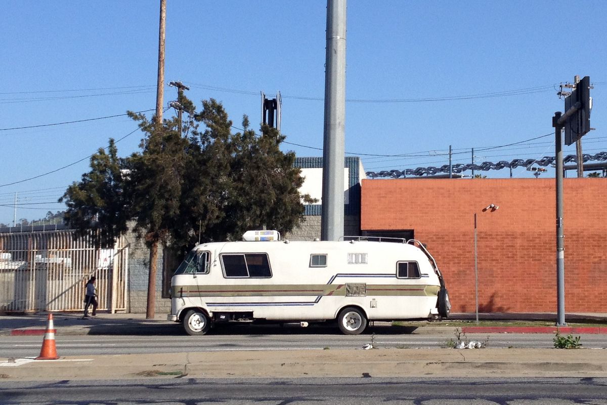 An RV parked in an industrial area. 