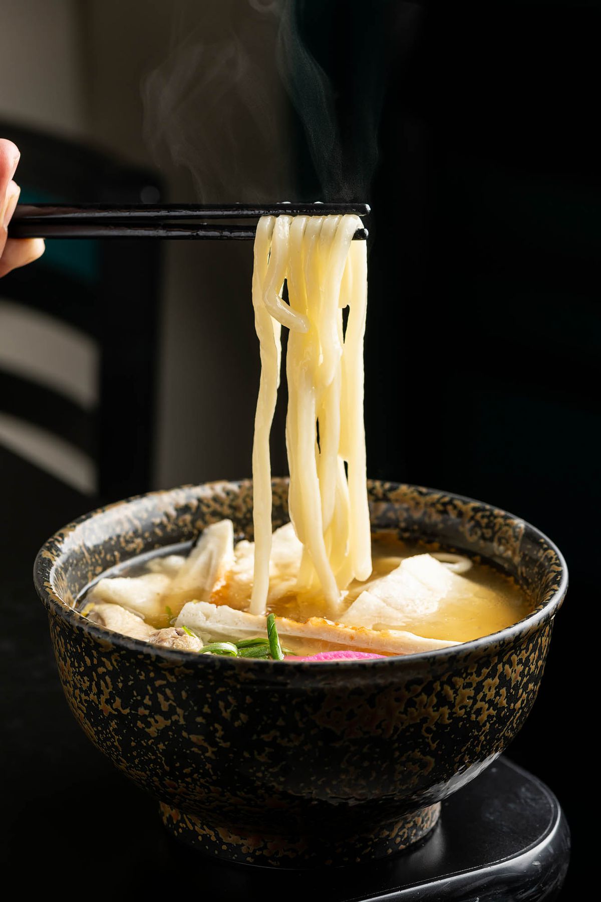 Udon noodle being pulled from a black bowl at Ducks in San Gabriel.