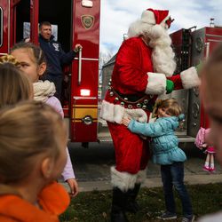 Vivian Terry, 4, leans in to hug Santa Claus as he arrives at the Sugar House Santa Shack in Salt Lake City on Saturday, Nov. 26, 2016.