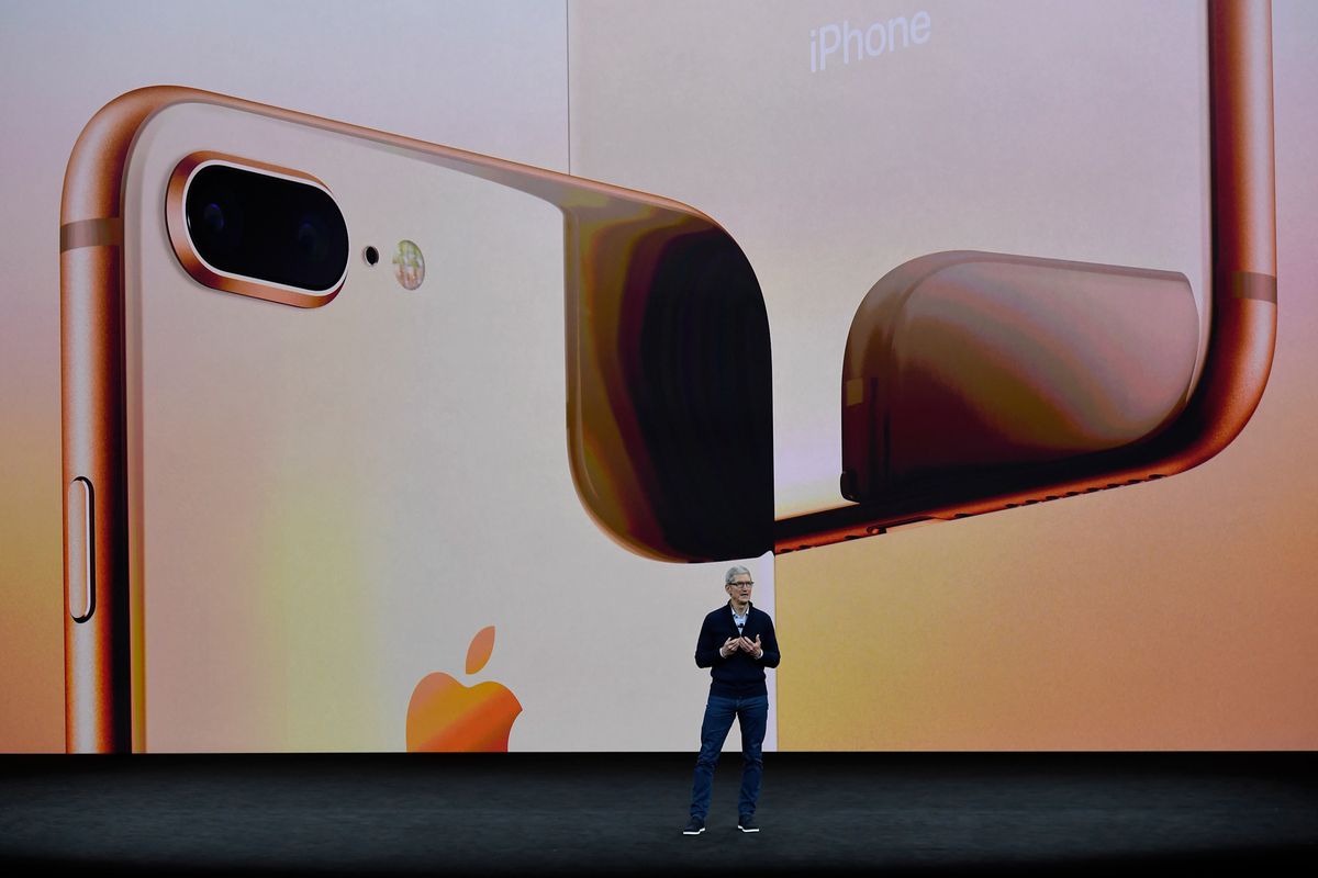 Apple CEO Tim Cook onstage in front of a giant iPhone