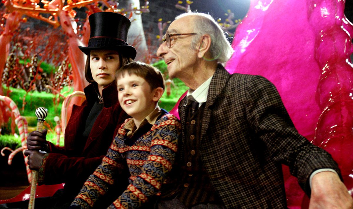 Willy Wonka (Johnny Depp) stares forbiddingly at Charlie (Freddie Highmore) and his grandfather (David Kelly) as they sit in a giant ship made of candy in Tim Burton’s Charlie and the Chocolate Factory