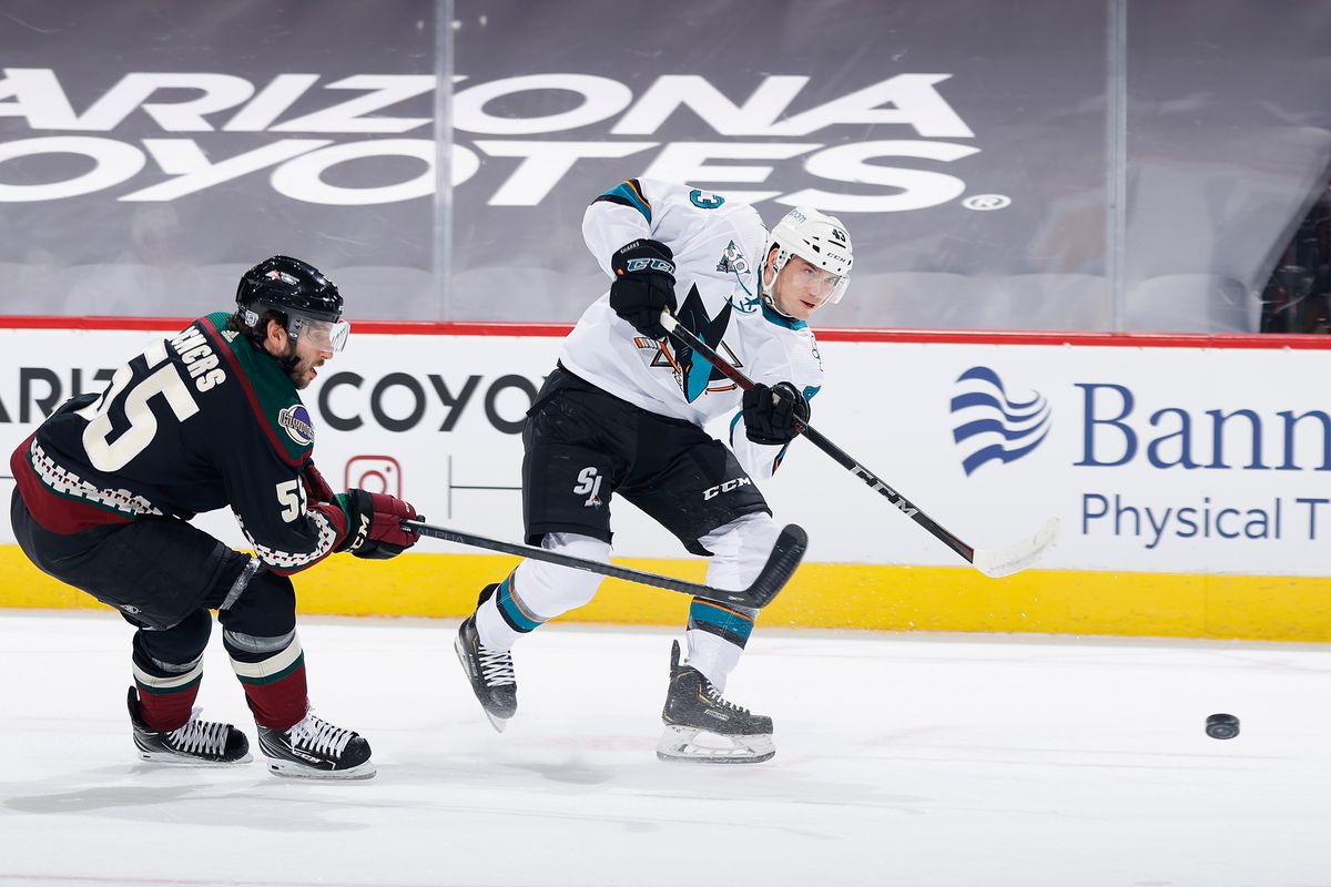 John Leonard #43 of the San Jose Sharks shoots the puck ahead of Jason Demers #55 of the Arizona Coyotes during the first period of the NHL game at Gila River Arena on January 14, 2021 in Glendale, Arizona.