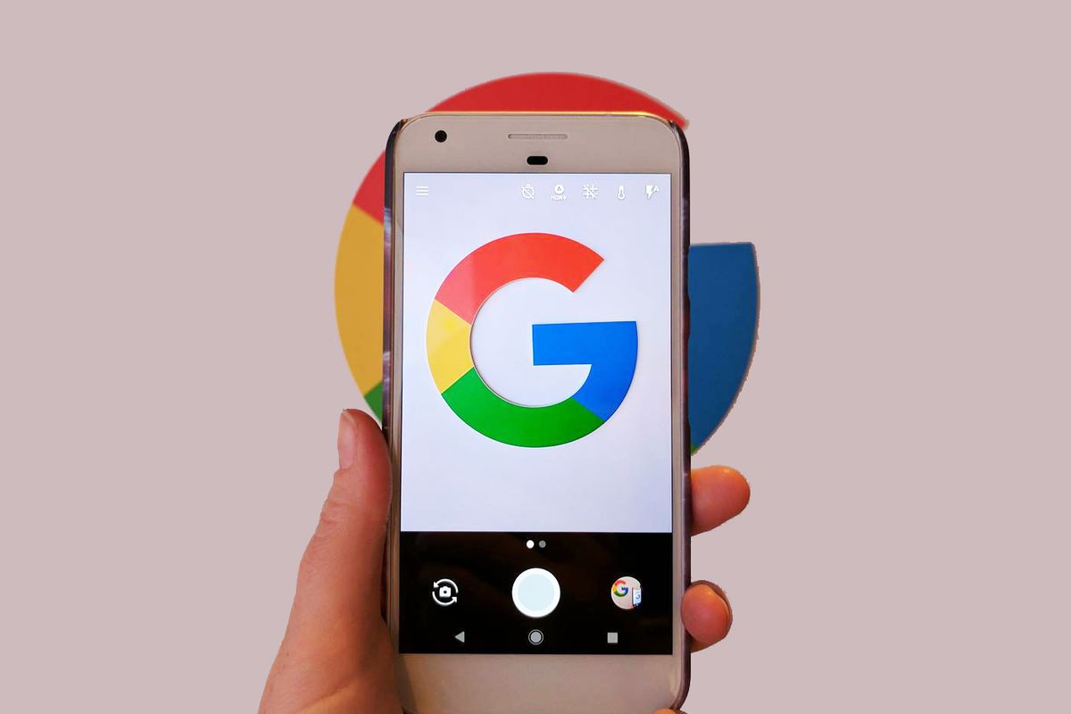 The Google pixel phone held by a hand on a pinkish background 