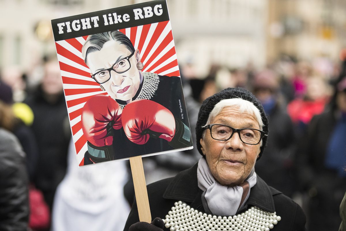 Demonstrator carrying a sign with Ginsburg in boxing gloves, reading: “Fight like RBG”