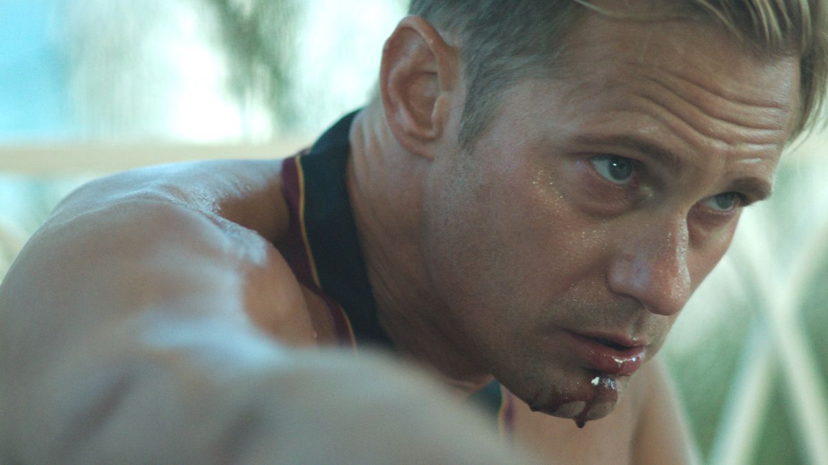James (Alexander Skarsgård), Infinity Pool'da diz çökmüş ve siyah köpek tasması takarken yakın çekimde ağzından kan damlıyor.