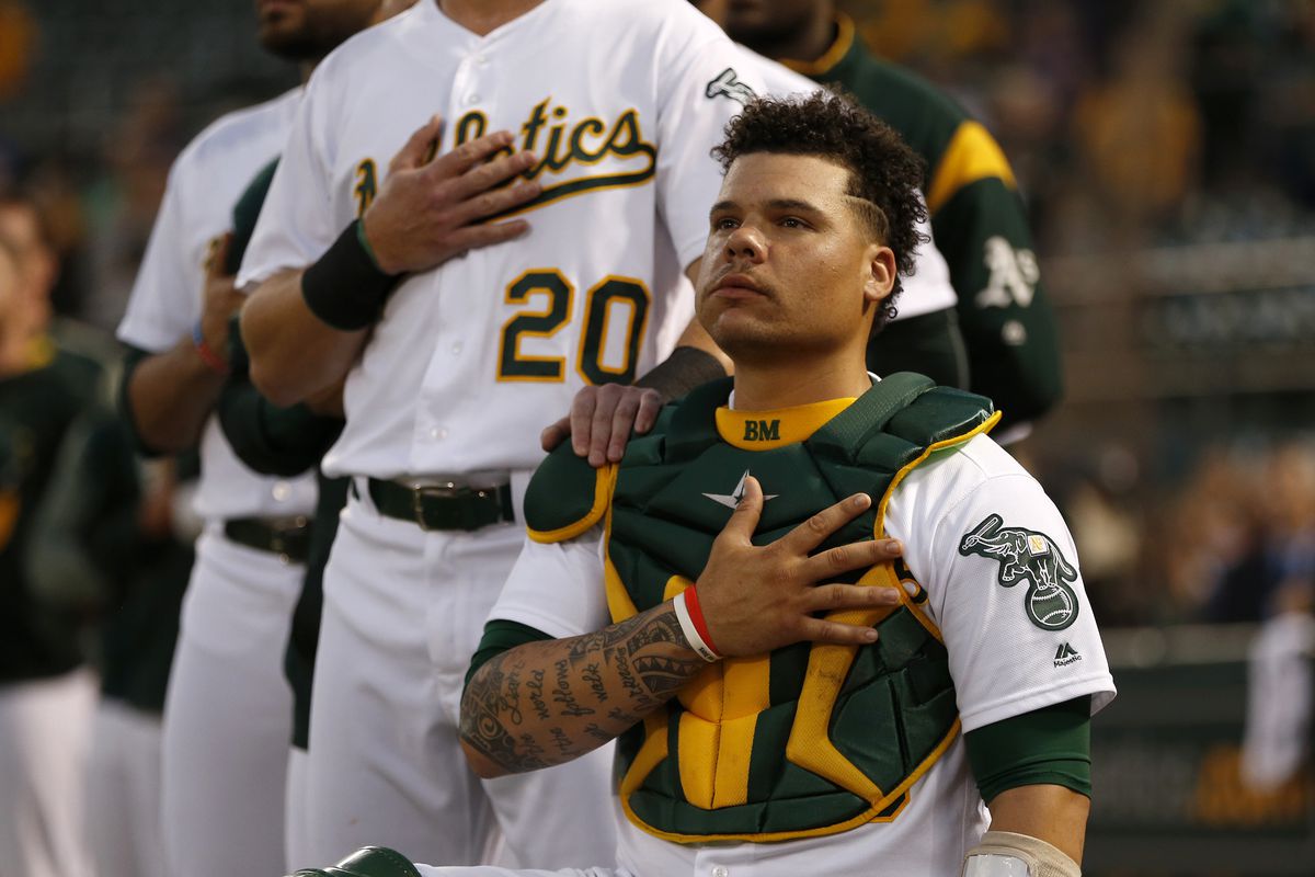 Oakland Athletics’ Bruce Maxwell (13) kneels next to Oakland Athletics’ Mark Canha (20) during the National Anthem before their game against the Seattle Mariners at the Coliseum in Oakland, Calif., on Monday, September 25, 2017. (Nhat V. Meyer/Bay Area Ne