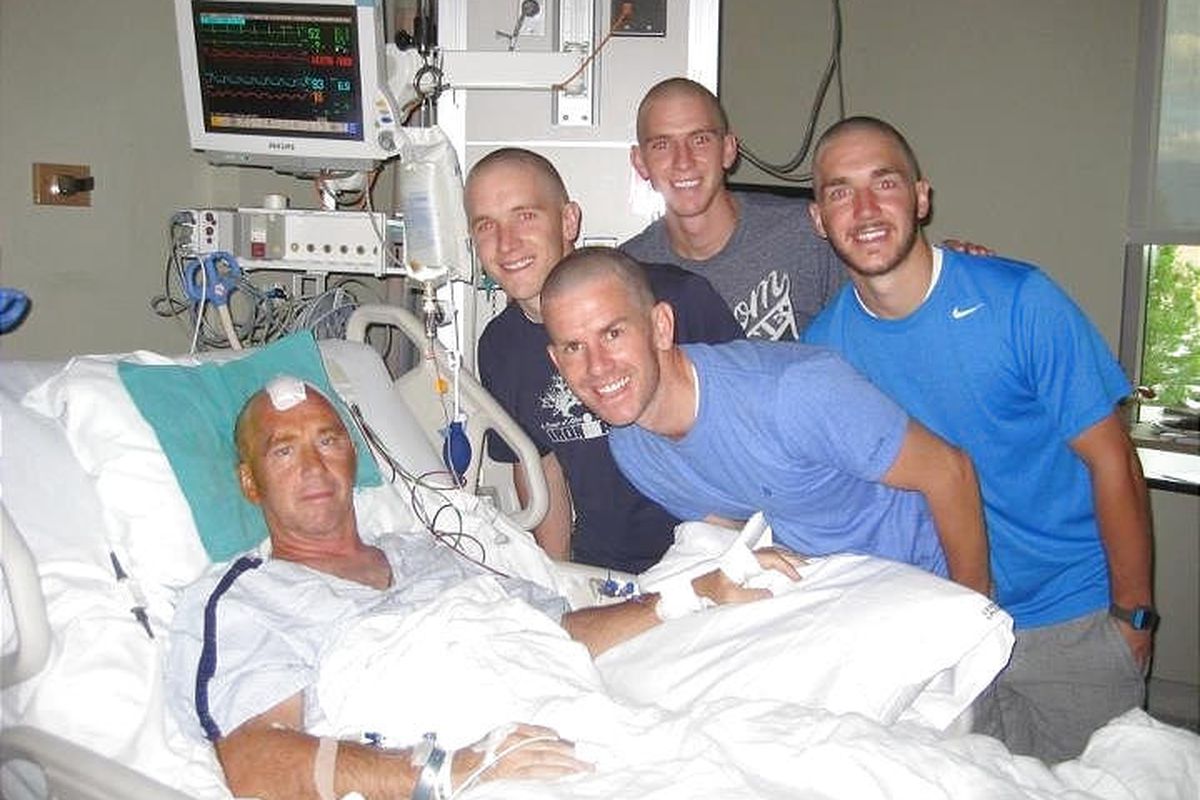 Dean Bullock rests in the hospital after undergoing surgery to remove a tennis ball-sized tumor  from his brain last summer. He is flanked by four of his sons, from left, Jeff, Ryan, Sean and Greg. 
