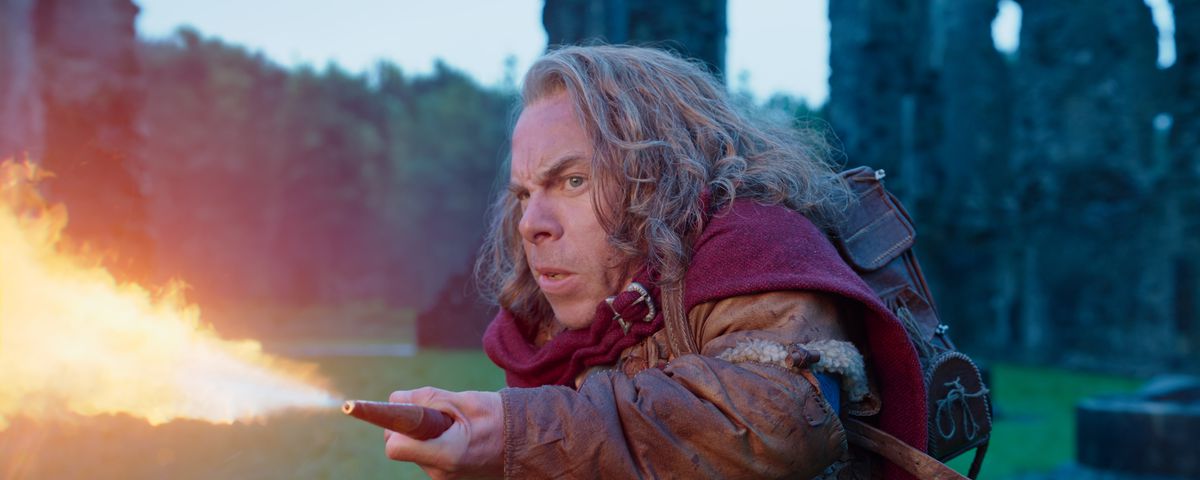 Willow Ufgood (Warwick Davis) shoots fire from a magical flamethrower in Lucasfilm’s WILLOW