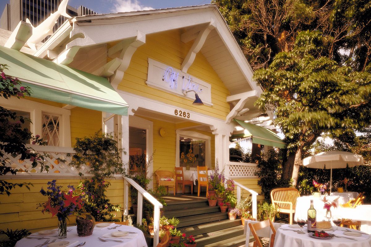 A sunny front porch for a tiny yellow restaurant inside a converted house.