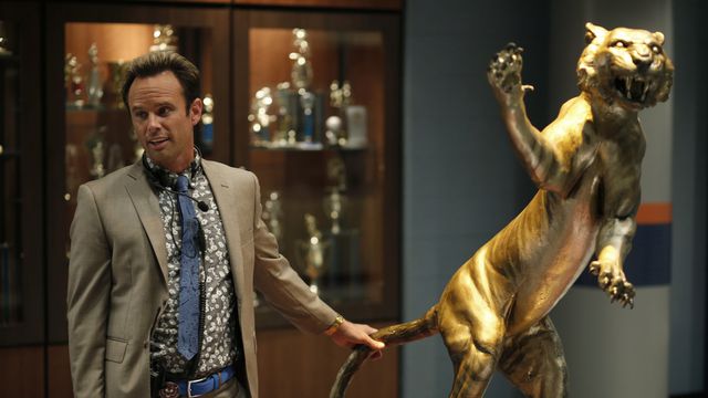 Lee (Walton Goggins) stands behind a statue of a tiger in Vice Principals