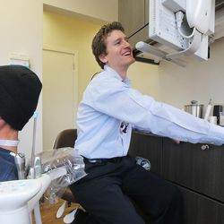 Dr. Spencer Updike of South Temple Dental looks at X-rays as he conducts a free dental screening on Derick Balser in Salt Lake City on Monday, March 21, 2016. Updike gave Balser some advice on things that can be done to help with his dental health.