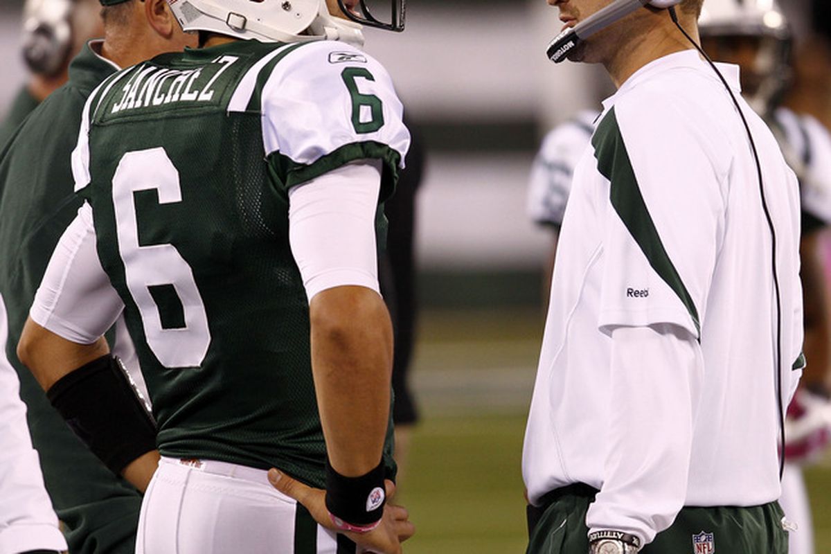 Mark Sanchez of the New York Jets talks with offensive coordinator Brian Schottenheimer during their game against the Miami Dolphins at MetLife Stadium on October 17, 2011 in East Rutherford, New Jersey.  (Photo by Jeff Zelevansky/Getty Images)