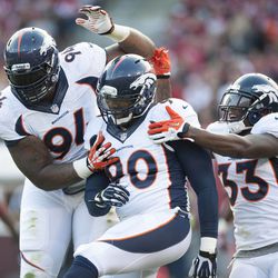  Denver Broncos defensive tackle Terrance Knighton (94) and outside linebacker Shaun Phillips (90) and safety Duke Ihenacho (33) celebrate after scoring against the San Francisco 49ers during the second quarter at Candlestick Park.