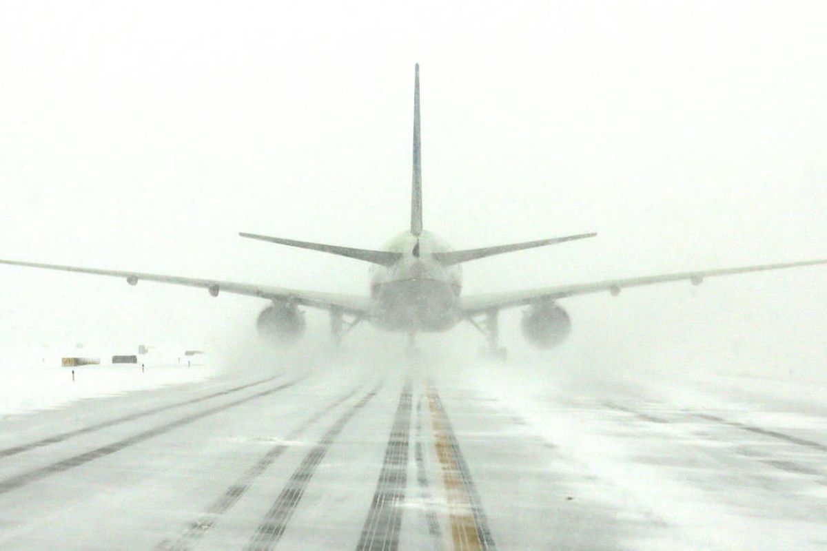 A United Airlines jet blows snow on a runway at O'Hare International Airport, Sunday, Feb. 1, 2015, in Chicago. More than 1,100 flights have been canceled at Chicago's airports and snow-covered roads are making travel treacherous. (AP Photo/Nam Y. Huh)