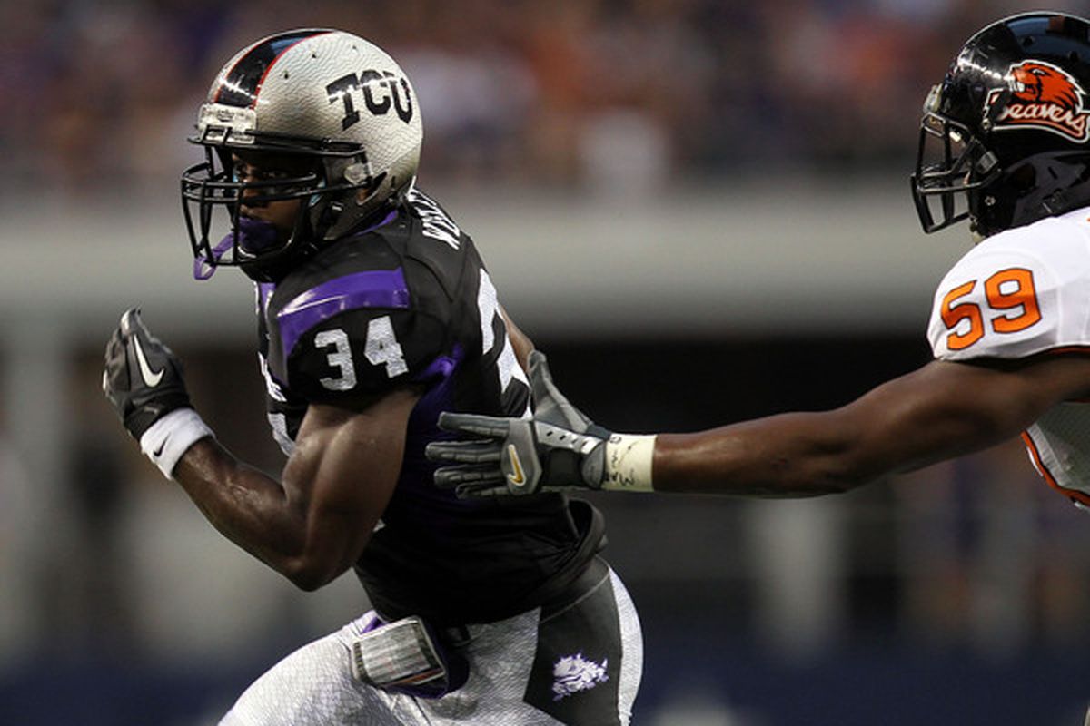 ARLINGTON TX - SEPTEMBER 04:  Tailback Ed Wesley #34 of the TCU Horned Frogs runs the ball past Dwight Roberson #59 of the Oregon State Beavers at Cowboys Stadium on September 4 2010 in Arlington Texas.  (Photo by Ronald Martinez/Getty Images)