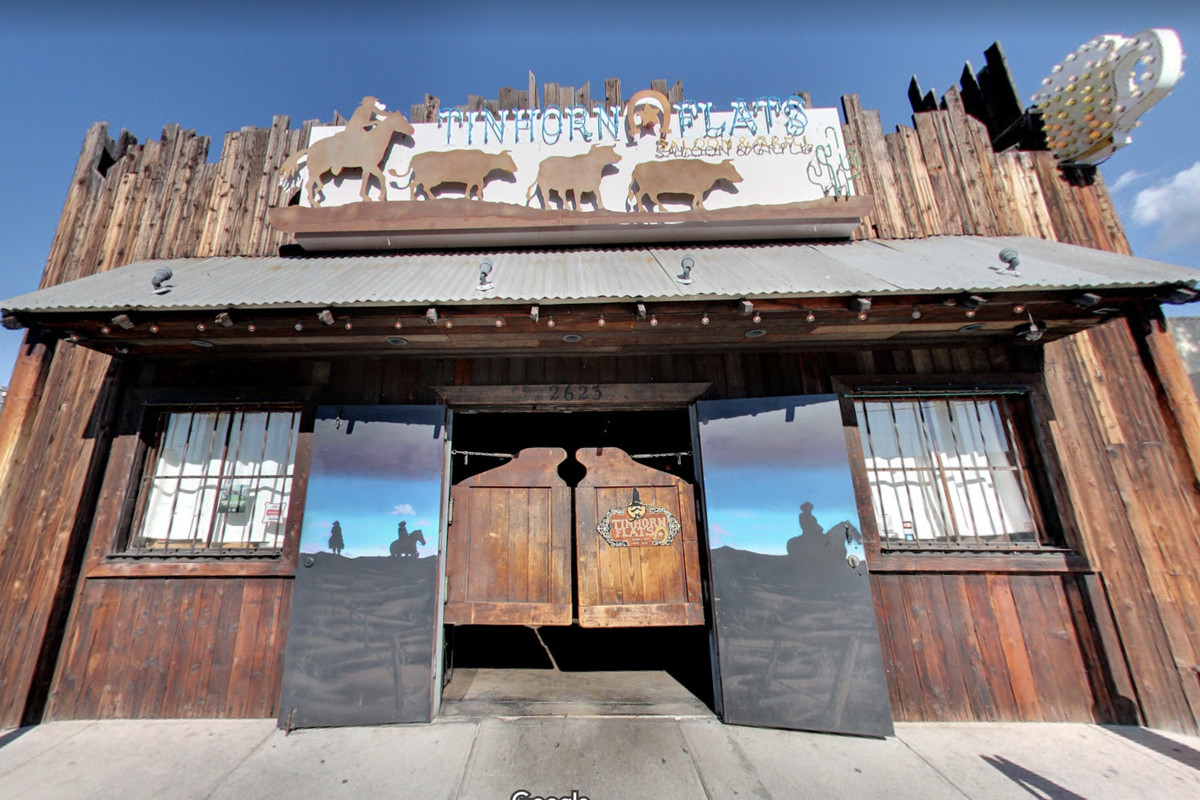 A Western-themed bar from the front, at an angle, showing saloon doors and blue skies beyond.