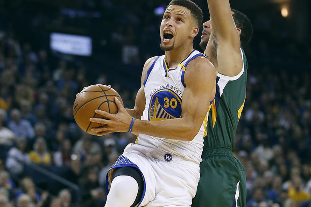 Golden State Warriors guard Stephen Curry (30) drives to the basket against Utah Jazz forward Trey Lyles, right, during the first half of an NBA basketball game Tuesday, Dec. 20, 2016, in Oakland, Calif. (AP Photo/Tony Avelar)