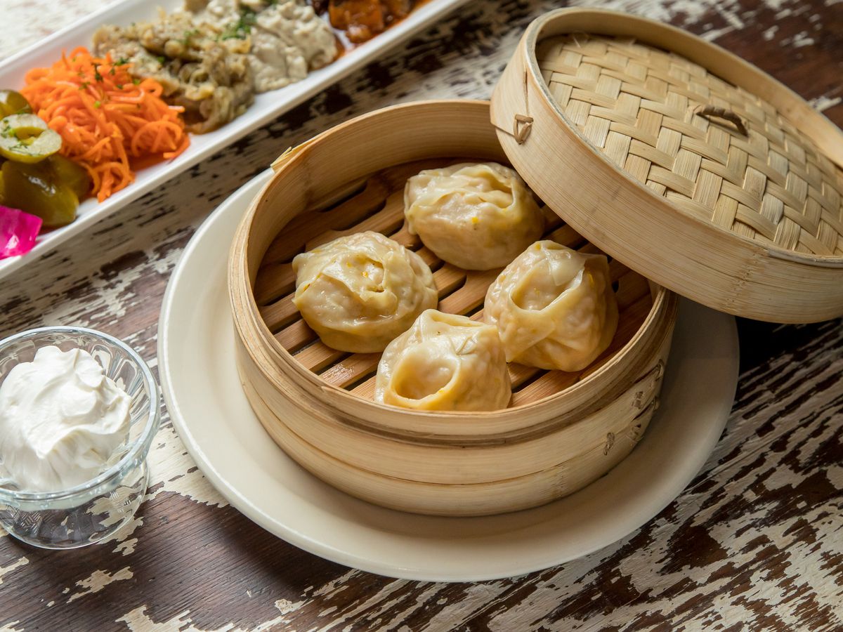 Dumplings in a bamboo container, with the lid half-off