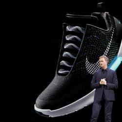An image of the Nike HyperAdapt 1.0 is projected on a screen as Nike CEO Mark Parker speaks during a news conference, Wednesday, March 16, 2016, in New York. 