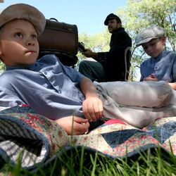 William Jones, left, and Thomas Jones relax at Fort Douglas Day in Salt Lake City on Saturday, June 15, 2013. Behind them is Caleb Gray playing guitar.