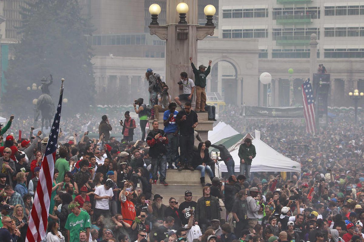 Members of a crowd numbering tens of thousands smoke marijuana and listen to live music, at the Denver 420 pro-marijuana rally at Civic Center Park in Denver on Saturday, April 20, 2013. Even before the passage in November 2012 of Colorado Amendment 64 pr