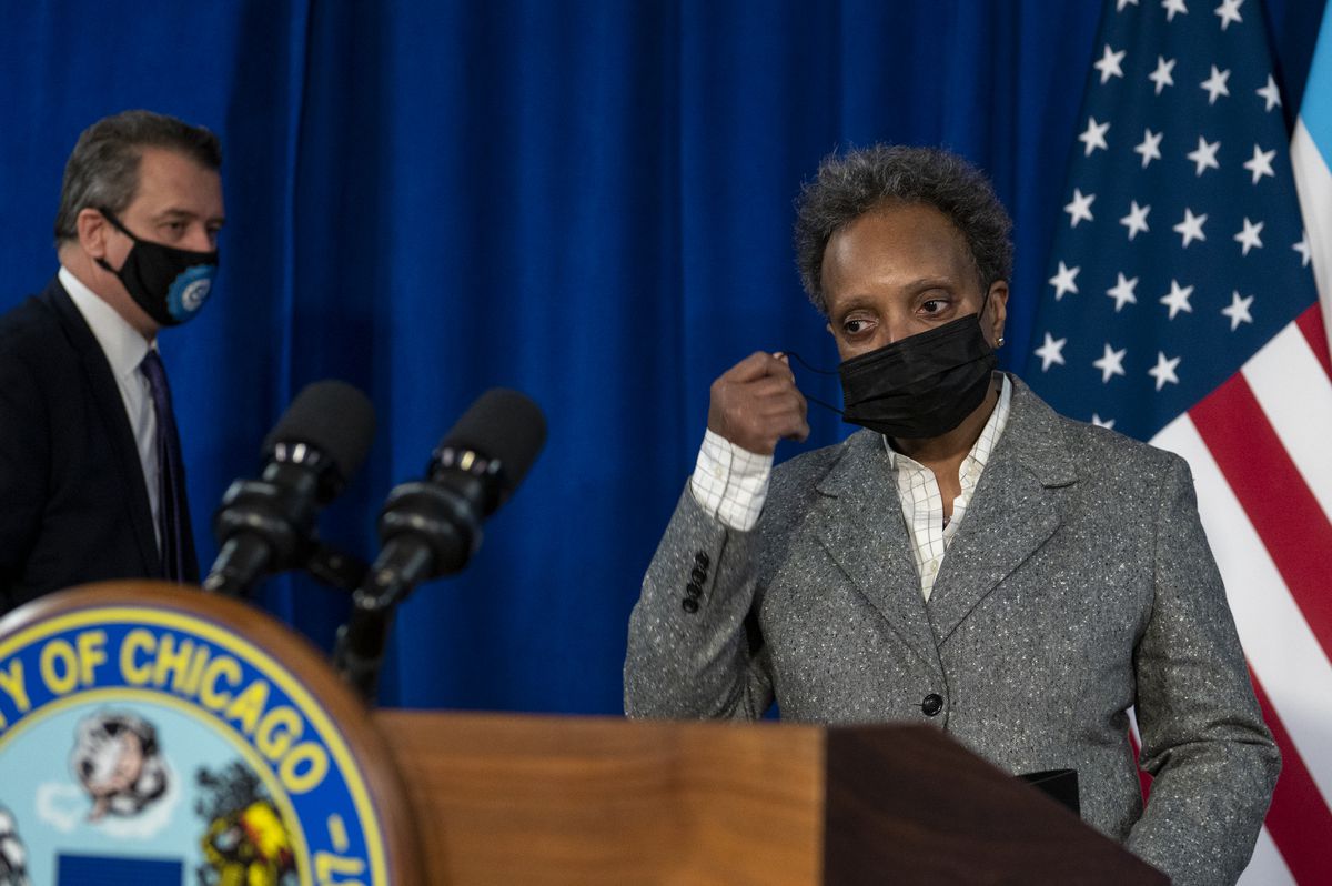 Mayor Lori Lightfoot removes her mask at a City Hall news conference Tuesday.