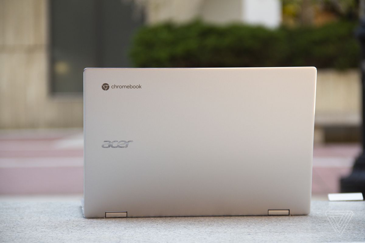 The Acer Chromebook Spin 513 open, seen from the back, on a stone bench.