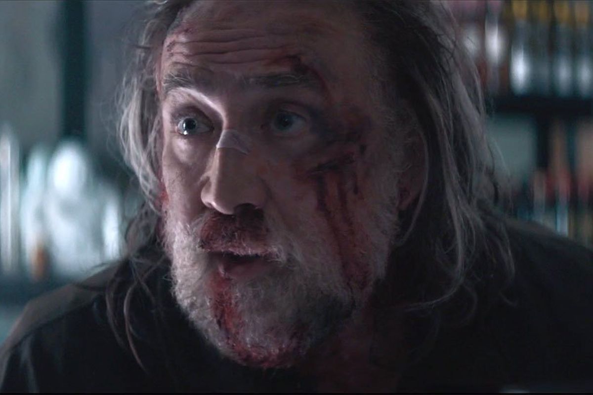 Nicolas Cage with a disheveled beard covered in blood in the movie Pig.