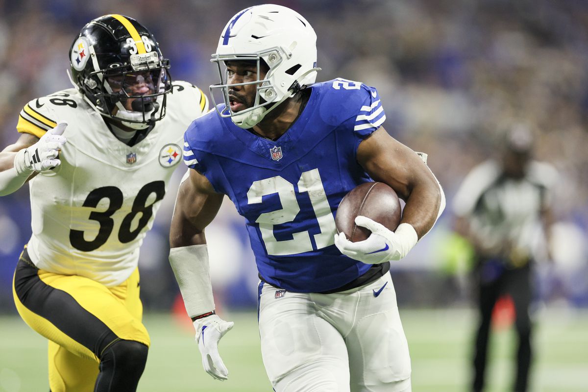 Zack Moss #21 of the Indianapolis Colts runs past Mykal Walker #38 of the Pittsburgh Steelers while scoring a receiving touchdown during the second quarter at Lucas Oil Stadium on December 16, 2023 in Indianapolis, Indiana.