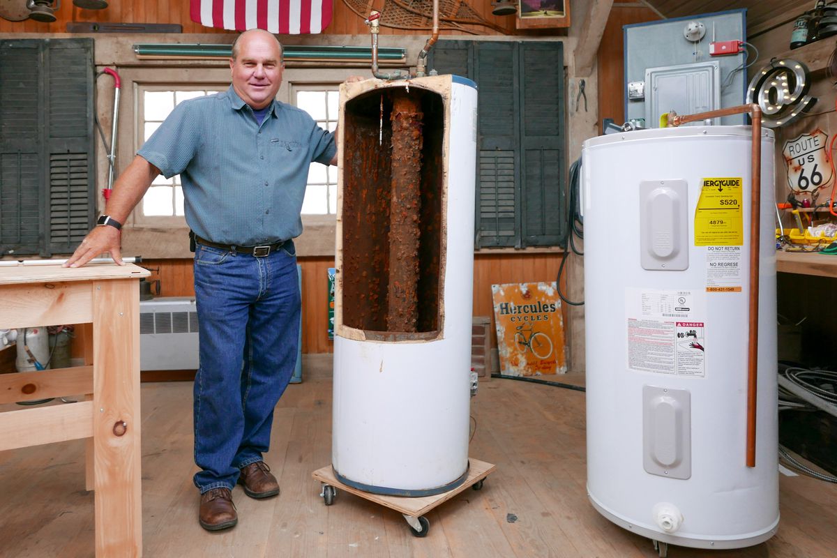 Richard Trethewey standing next to a bisected hot water heater. 