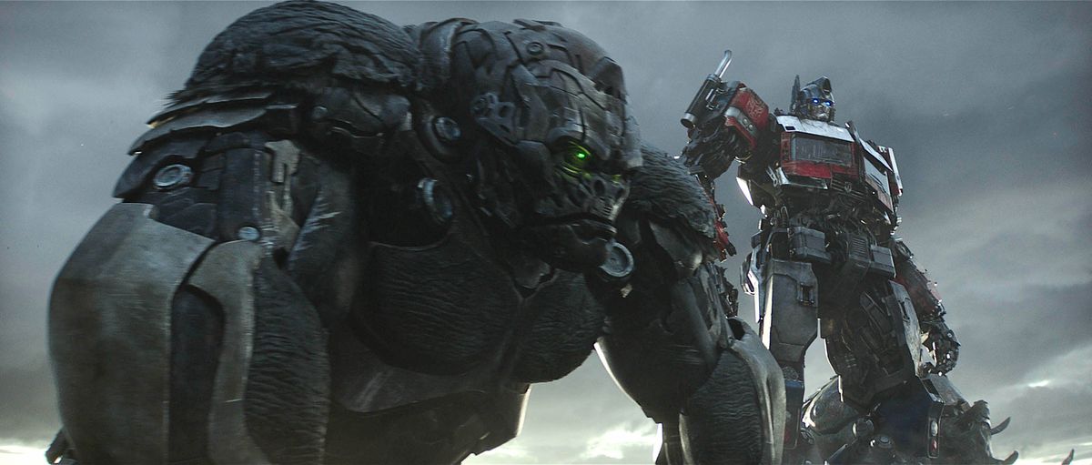 Optimus Primal, a giant gorilla-shaped robot, stands with Optimus Prime, a giant man-shaped robot, in Transformers: Rise of the Beasts