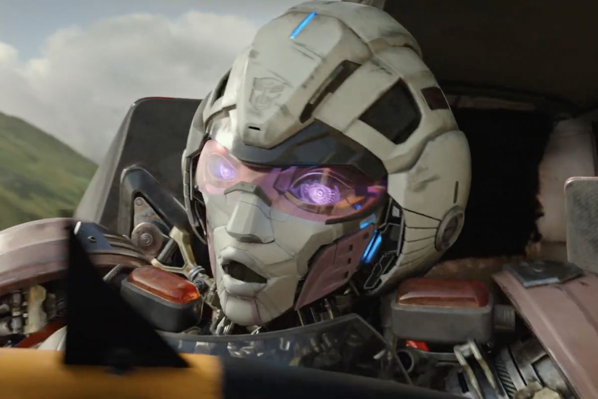 Arcee, the white and red female motorcycle Transformer, gasps as a missile flies by her face in Transformers: Rise of the Beasts