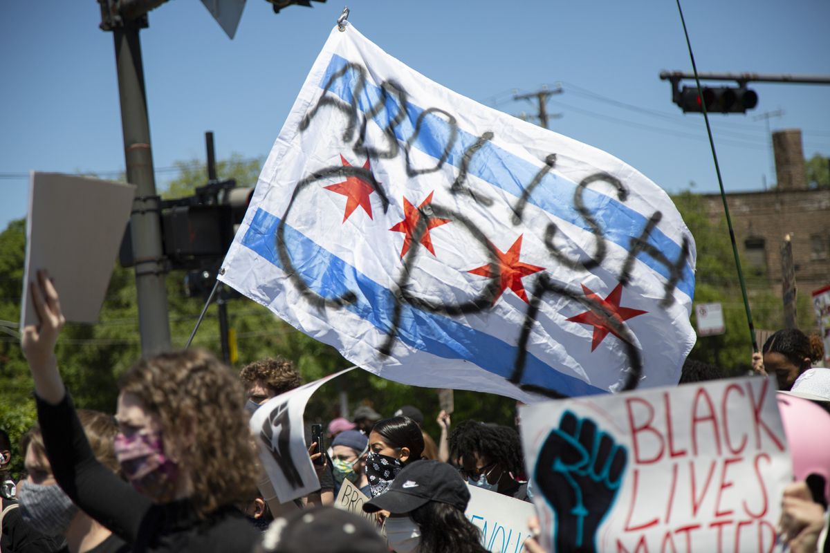 Protesters waved an “Abolish CPD” flag on East 63rd Street in Woodlawn last June.